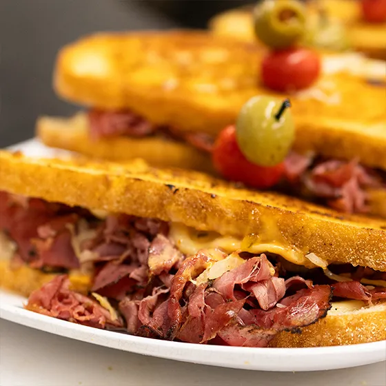 Grilled pastrami sandwiches with olives and tomatoes at Schmidt's Country Market